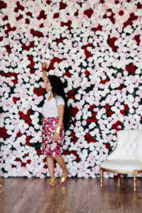 Portrait of Krista Suh in front of a wall of roses